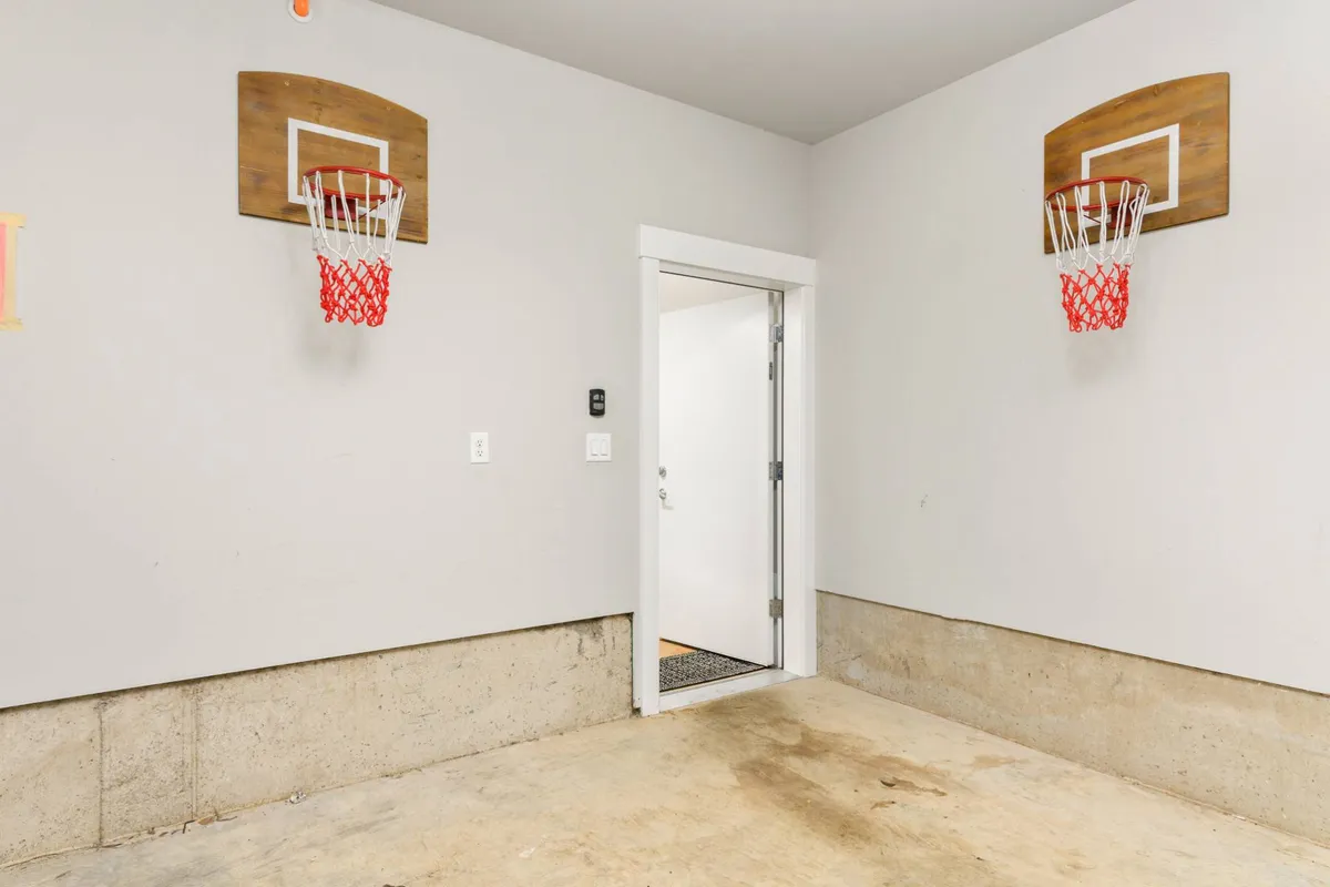 A fun, lighthearted space featuring two basketball hoops and an open doorway, hinting at opportunities for casual play and spontaneous family fun inside the home.